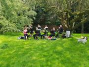 The ensemble playing under a tree
